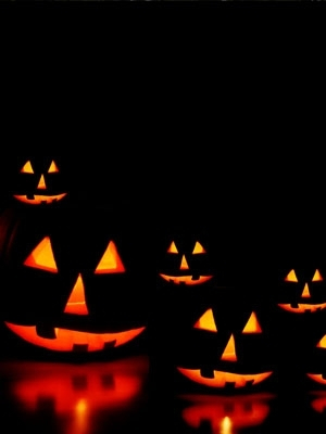 Five lit Jack-O-Lanterns in a black background